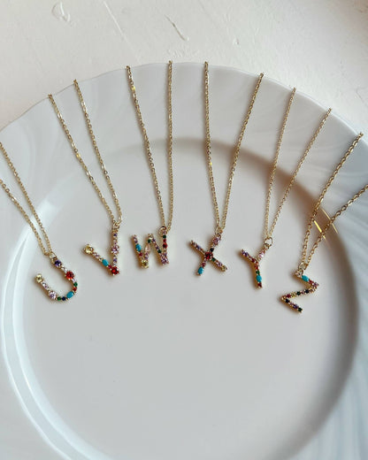 Necklaces with colorful letter pendants on a white plate