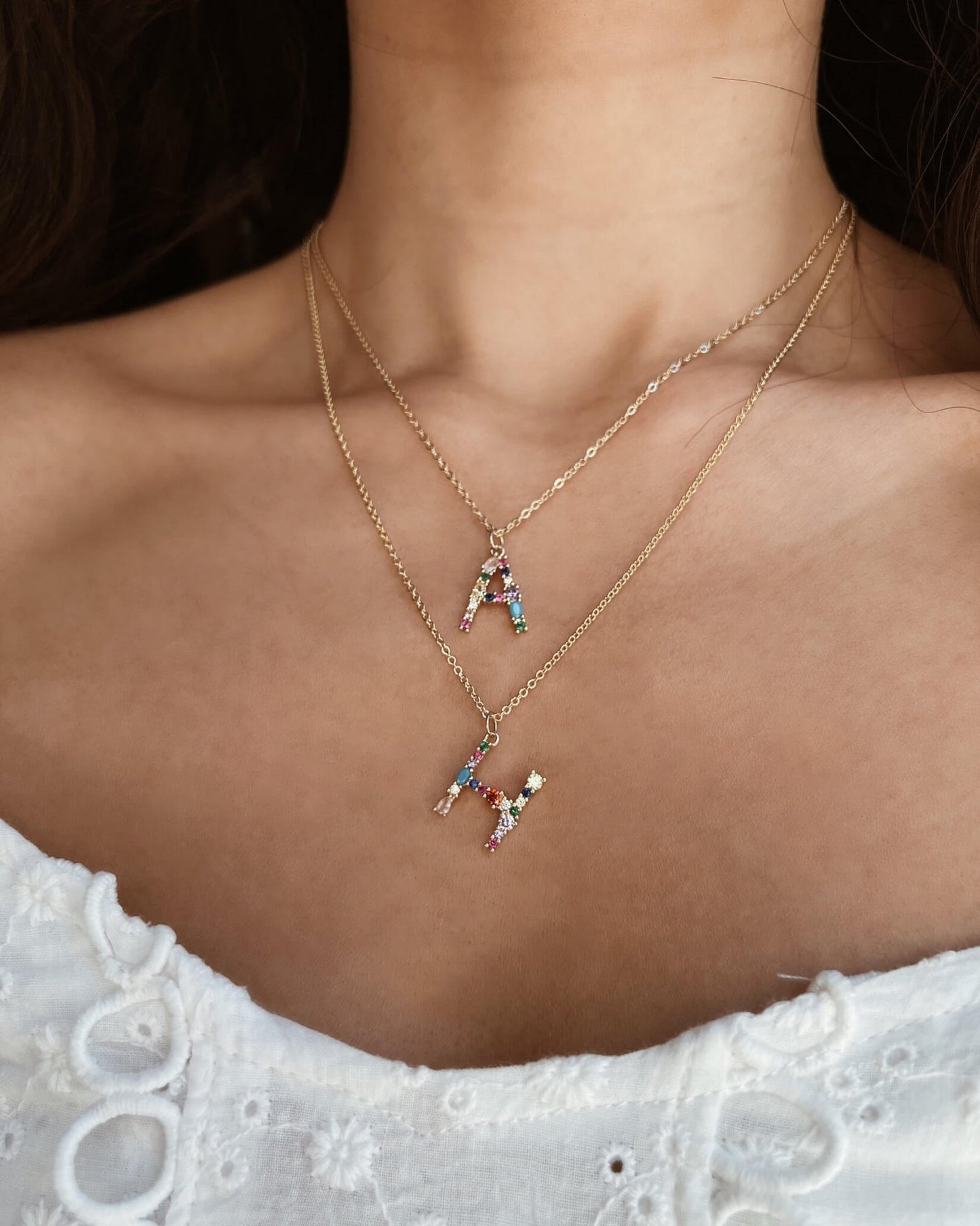 Necklace with a small penguin pendant worn by a person on a dark background