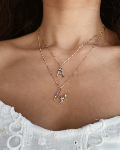 Necklace with a small penguin pendant worn by a person on a dark background