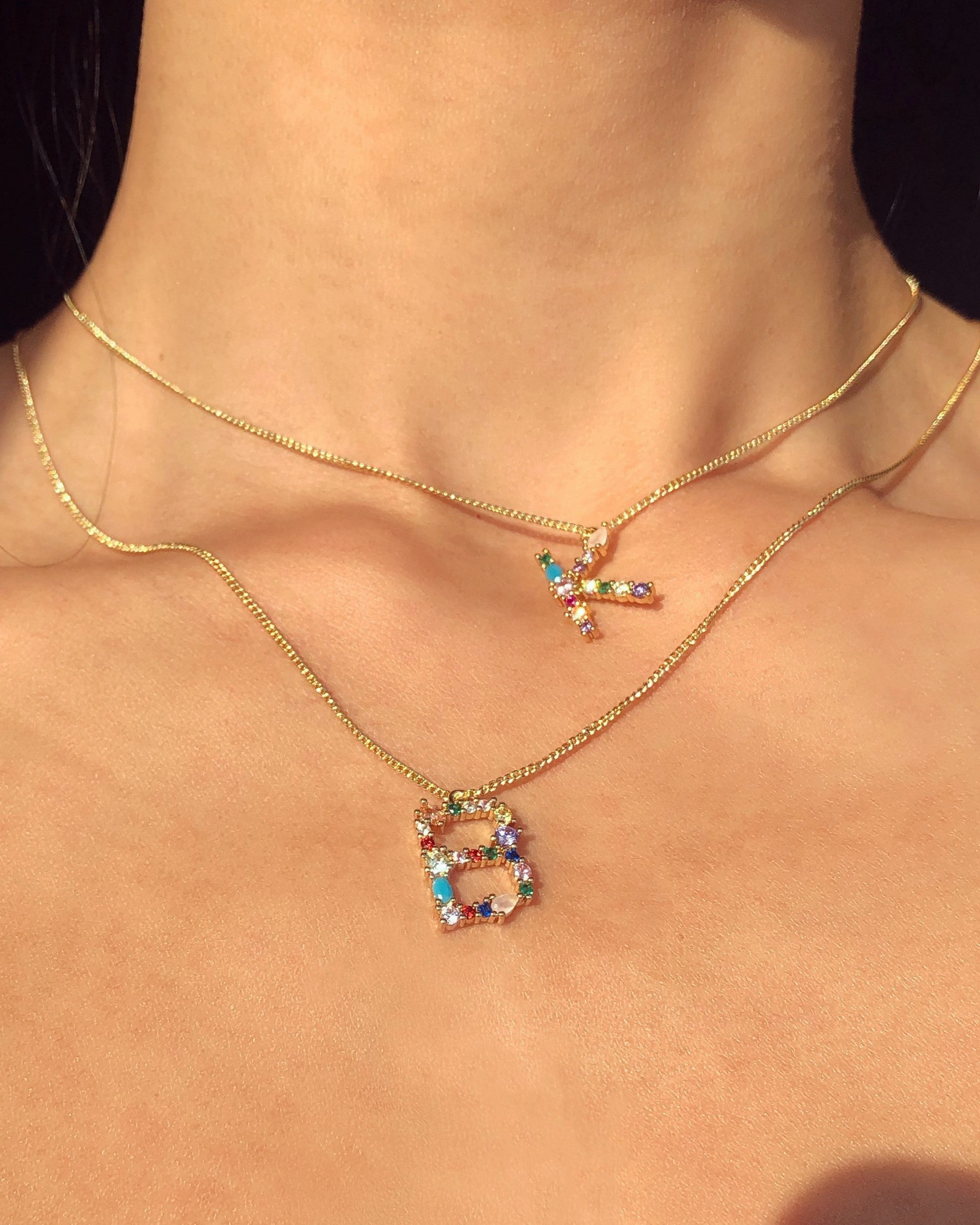 Necklace with colorful 'B' pendant on a person's neck