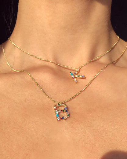 Necklace with colorful 'B' pendant on a person's neck
